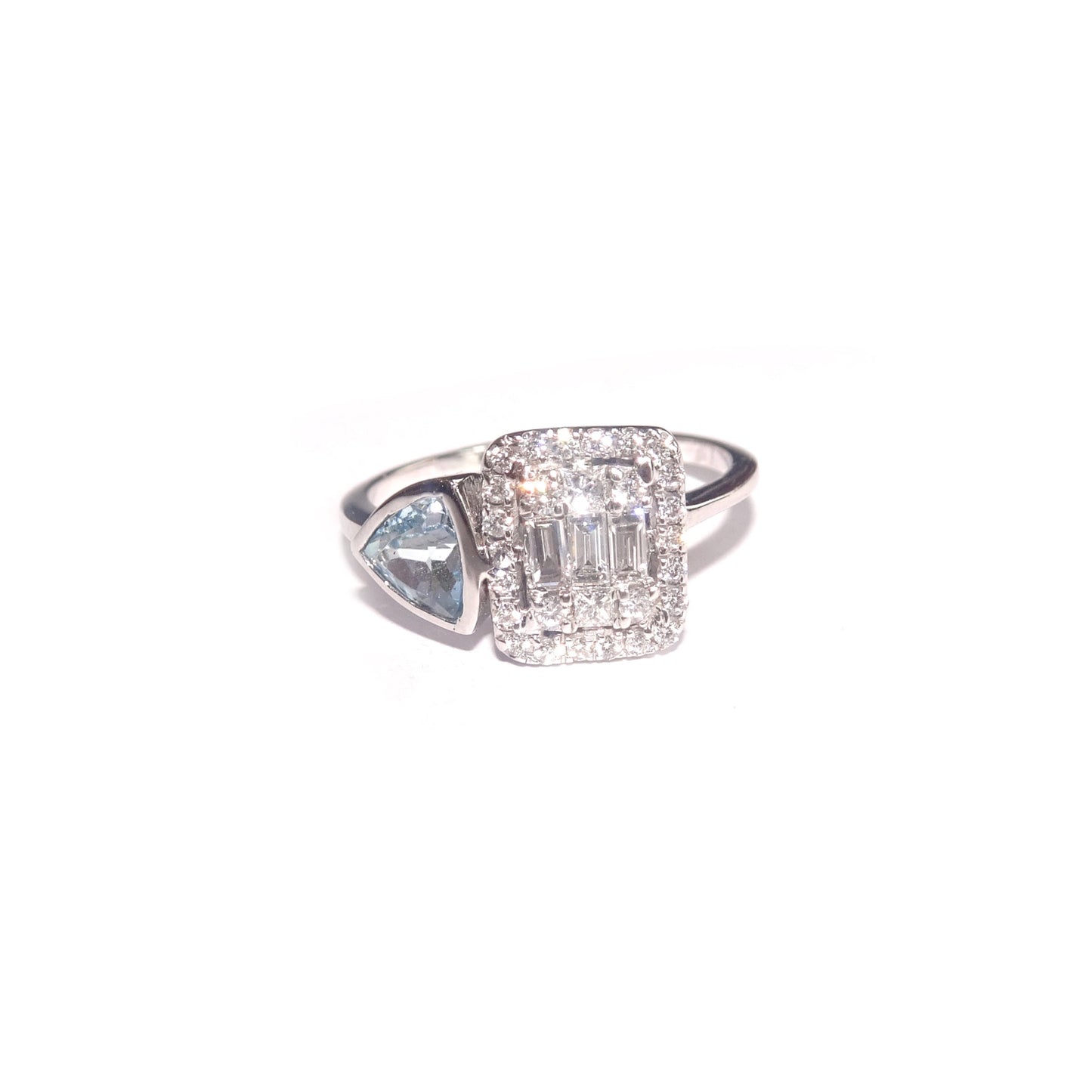 Surrounding the diamond is a beautiful trillion-cut topaz, which is a brilliant blue gemstone that complements the diamond and adds a pop of color to the ring.