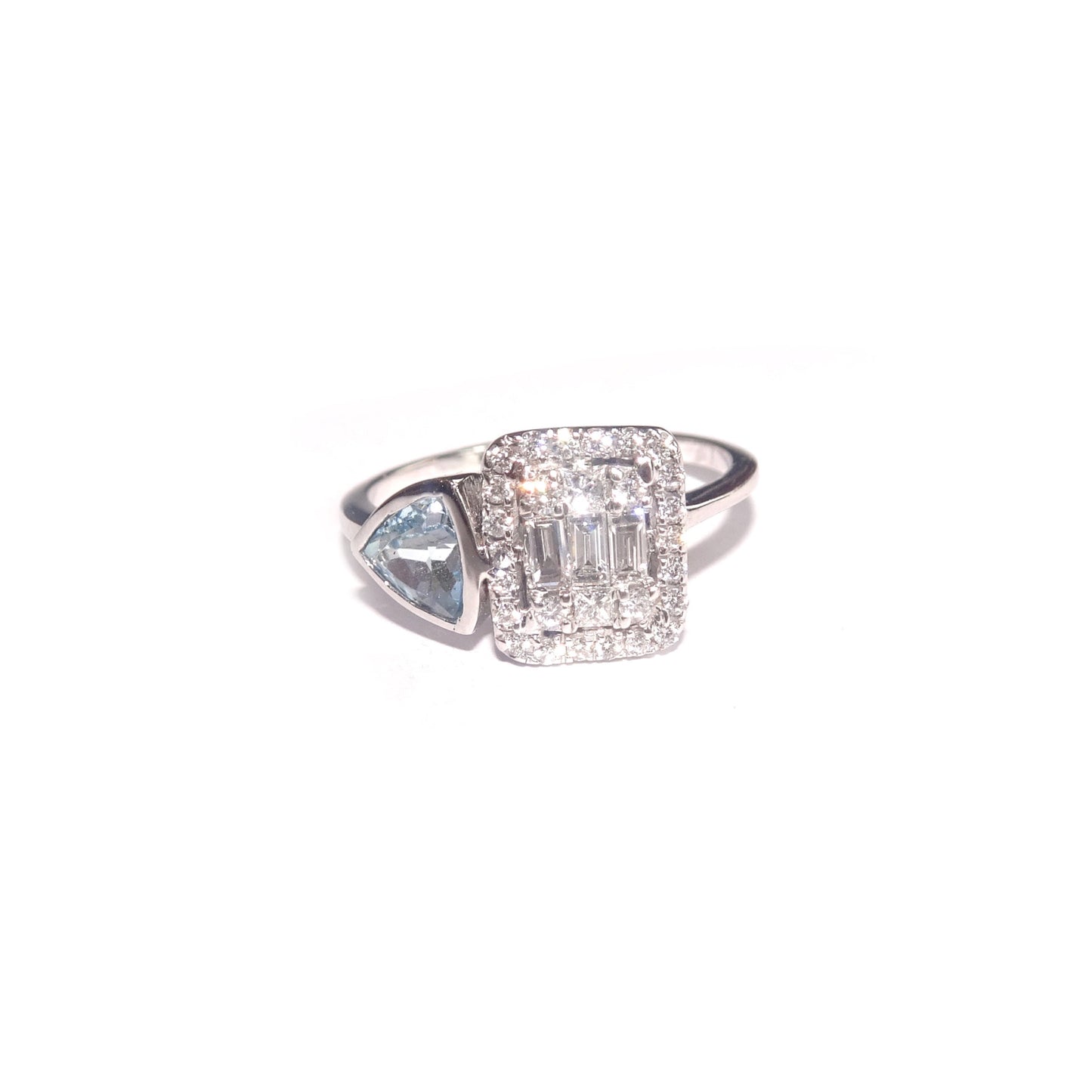 Surrounding the diamond is a beautiful trillion-cut topaz, which is a brilliant blue gemstone that complements the diamond and adds a pop of color to the ring. 