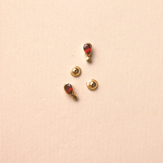18 karat yellow gold baby earrings featuring pear-shaped garnets