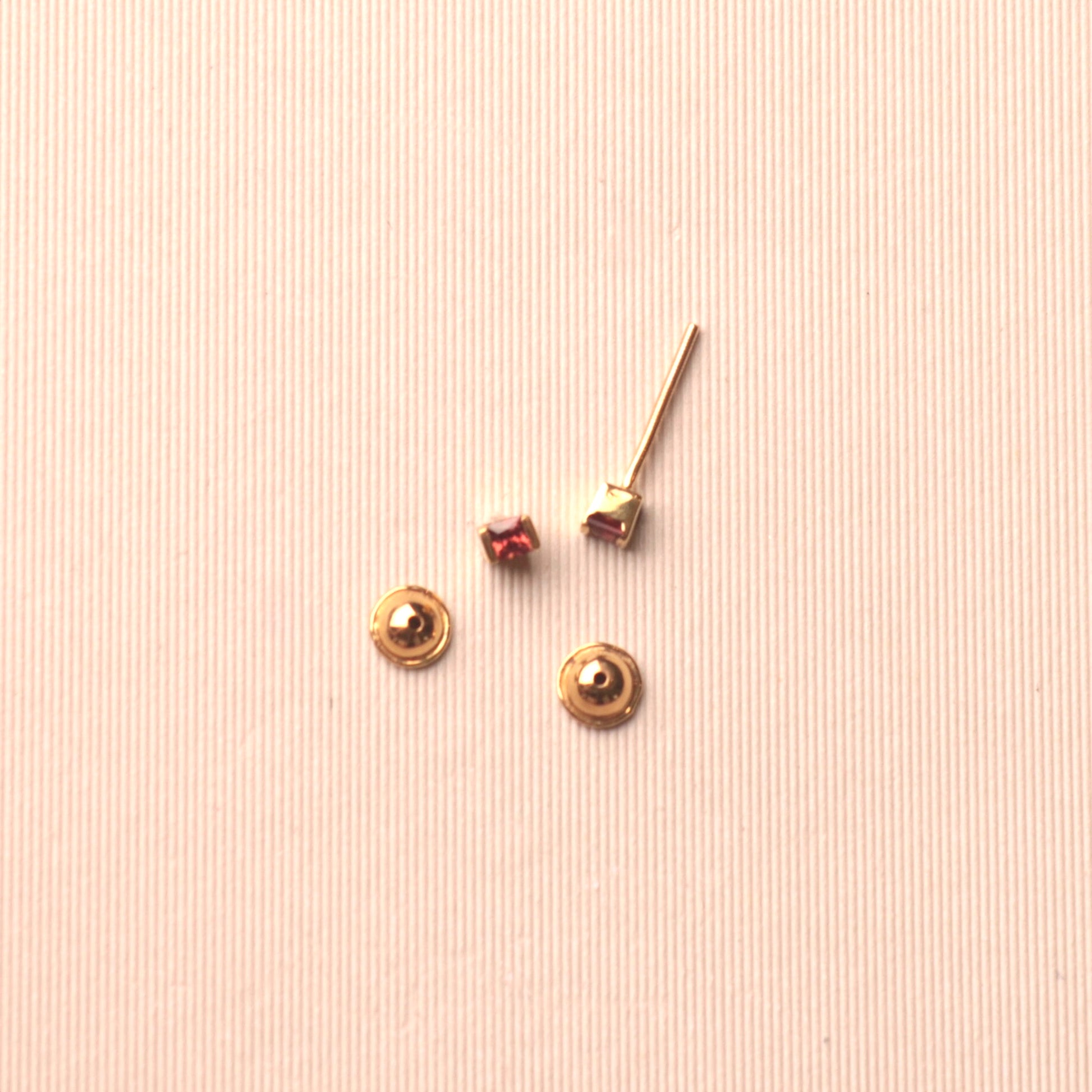 18 karat yellow gold baby earrings featuring princess-cut garnets 