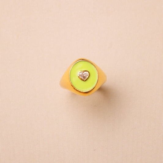 This 18-karat yellow gold ring is a stunning piece of jewelry that features a beautiful lime green enamel and a 0.20-carat heart-shaped diamond.